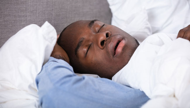 Young African Man Sleeping On Bed