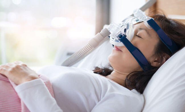 woman using cpap machine to stop choking and snoring